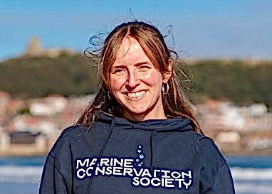 A landscape image of Marine Conservation Society staff member Lorna Donaghy, who is standing facing the camera wearing a dark blue Marine Conservation Society top